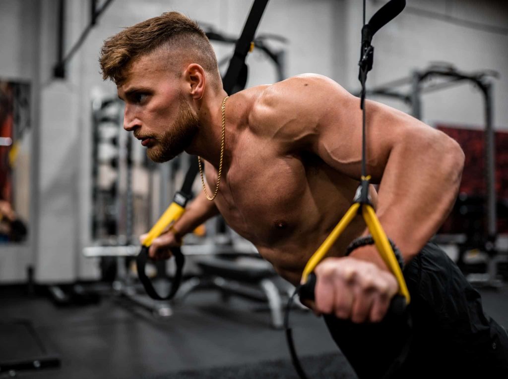 homem treinando flexão no trx