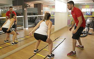 personal trainer e aluna em escada de agilidade