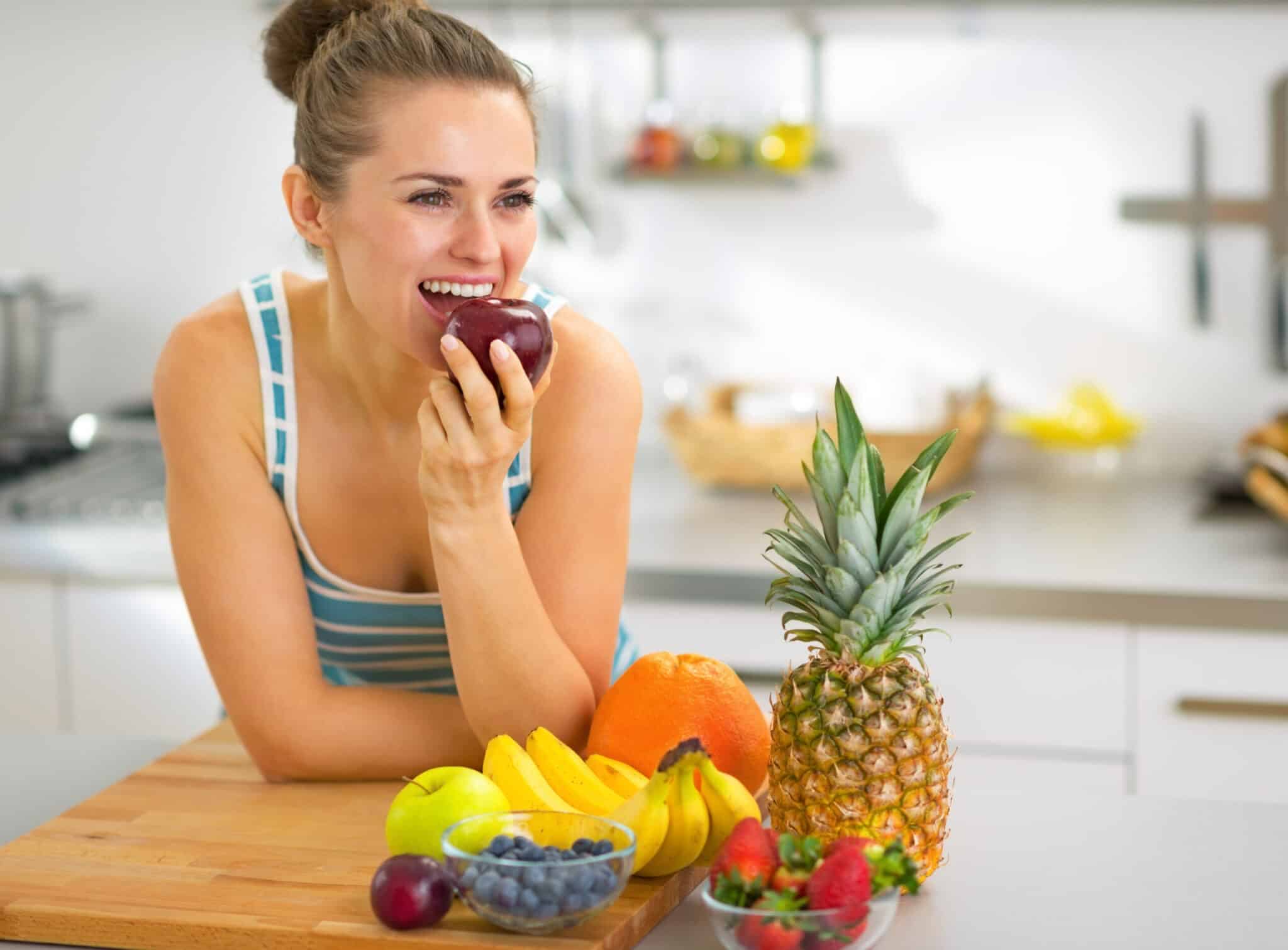 mulher comendo frutas adquirindo novo hábito criar hábitos saudáveis