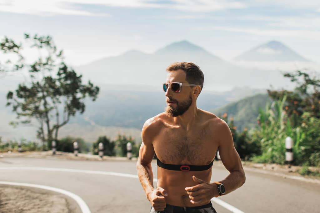 O Poder do Exercício na Prevenção de Doenças Cardíacas homem com frequecimentro correndo corrida de rua coração