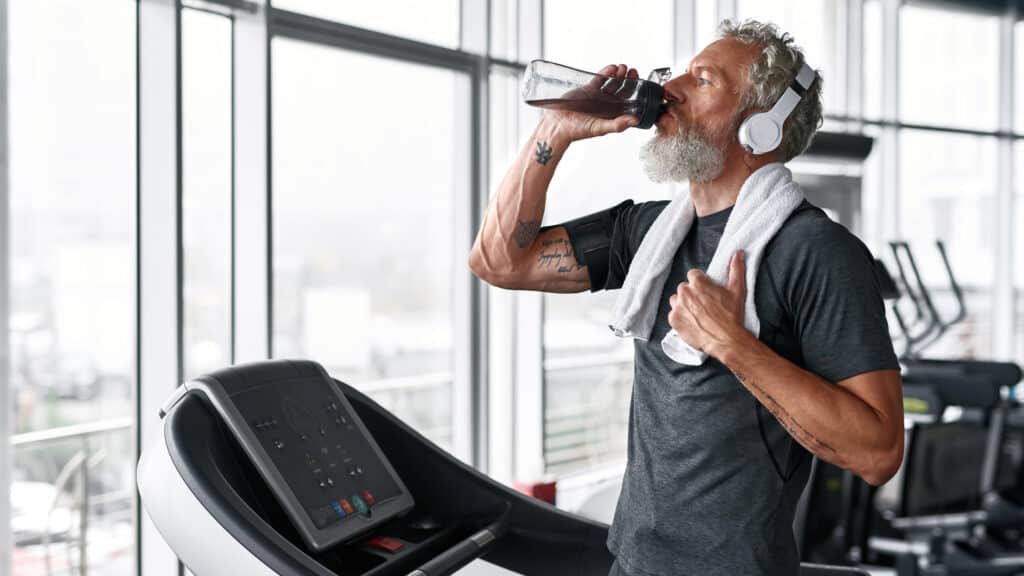 homem bebendo agua hidratação nos esportes corrida esteira