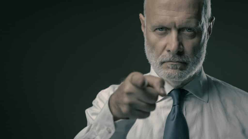 Corporate business executive pointing at camera, selection and recruitment concept