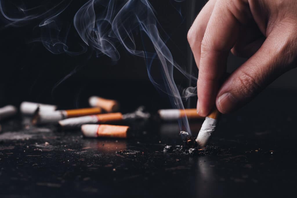 Close up hand held a cigarette to crush smoke of a burning, Stop smoking concept.World No Tobacco Day
